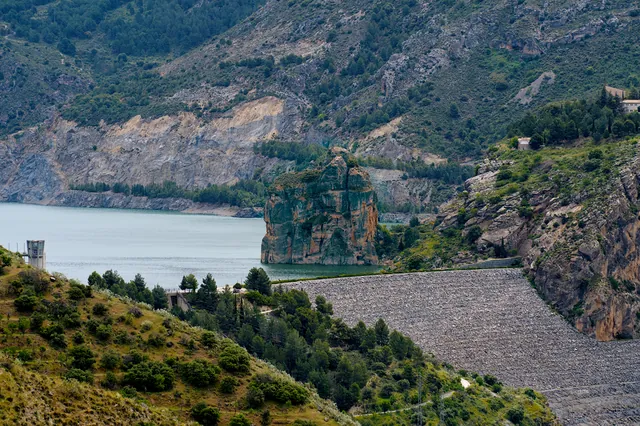 A dam and reservoir between steep mountain slopes