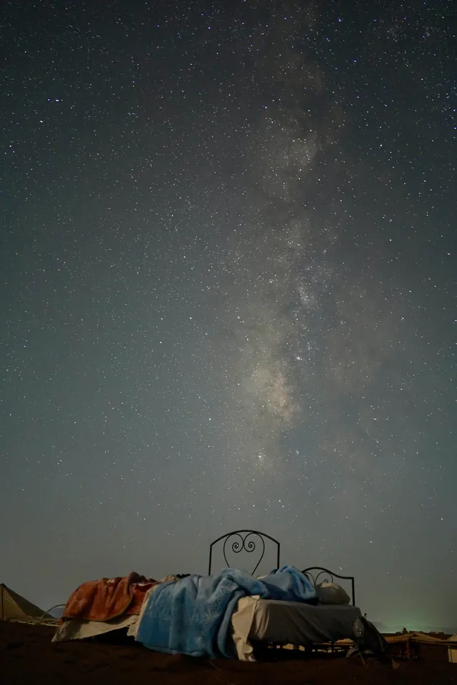 The Milky Way above beds set up outside in a desert camp